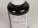 a bottle of black liquid sitting on top of a white table