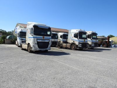 trois gros camions garés les uns à côté des autres sur un parking