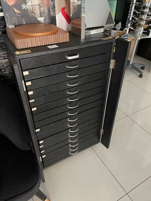 a black filing cabinet with a magazine on top of it
