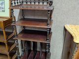 une étagère en bois à trois tablettes et un tableau accroché au mur