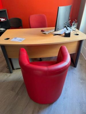 un bureau avec une chaise rouge et un ordinateur posé dessus