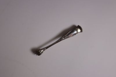 a silver spoon with a silver handle on a white surface