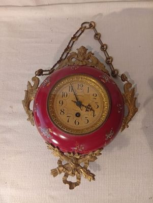 une horloge rouge et dorée accrochée au mur
