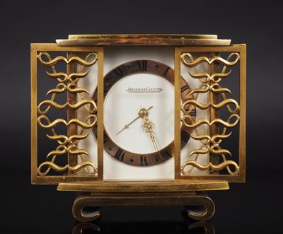 an image of a gold clock with a white face on a black background