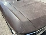 a dirty car parked on the side of the street