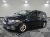 La Volkswagen Touran est garée dans une grande pièce au sol carrelé.