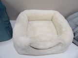 a white dog bed that is on a white table