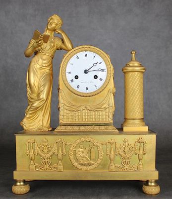 une horloge en or surmontée d'une statue