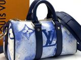 a blue and white louis vu bag next to a brown box
