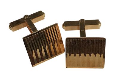 two pairs of gold and black cufflinks on a white background