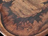 a close up of a wooden table with a carved design on it