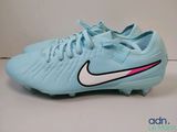 un gros plan sur une paire de chaussures de foot bleues posées sur une surface blanche