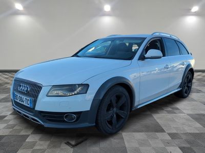Le SUV Audi blanc est garé dans une pièce au sol carrelé.