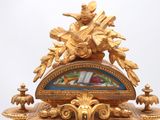 a gold clock with a man on top of it