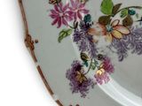 a plate with a floral design on it on a white surface