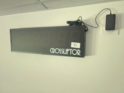 un téléviseur fixé au mur et muni d'une horloge