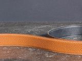 une ceinture en cuir marron munie d'une boucle en métal