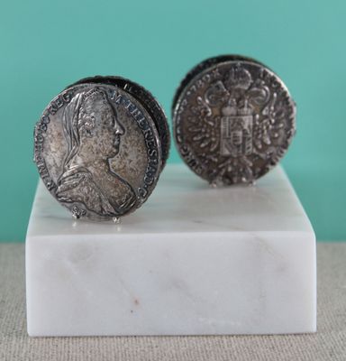 pair of silver coin cufflinks on a marble base
