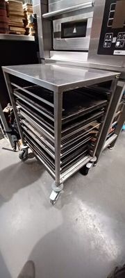 several trays of food sit in a stainless steel oven
