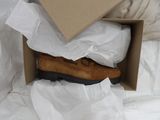 two pairs of shoes in a box on a bed