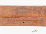 an old wooden box with a key in it on a white surface
