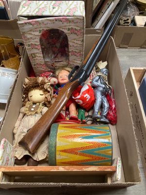 une boîte remplie d'objets divers, dont une arme à feu et d'autres objets