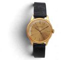 une image d'une montre-bracelet en or avec un bracelet en cuir noir
