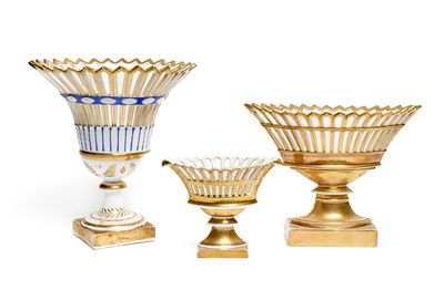 three gold vases sitting next to each other on a white surface