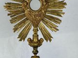 an image of a golden cross with a mirror on top of it