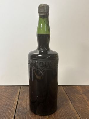 une vieille bouteille de whisky posée sur une table en bois