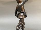bronze statue of a man holding a baseball bat on a base