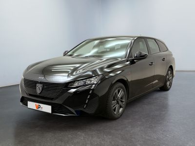 La voiture noire est garée dans une pièce aux murs blancs.