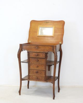 a small wooden desk with a mirror on top of it