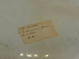 a piece of paper on the bottom of a white vase