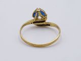 a close up of a gold ring with a blue stone in it