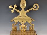 une statue en or représentant un homme tenant une croix et des clés