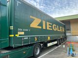 un camion vert garé sur un parking