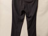 a black pants hanging on a hanger against a white wall