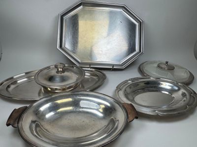 cinq assiettes en argent et un miroir posés sur une table