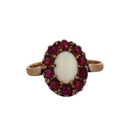 un gros plan d'une bague ornée d'une pierre blanche entourée de pierres rouges
