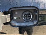 a close up of a person holding an electric car charger