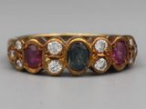 gros plan d'une bague en or avec trois pierres de couleurs différentes