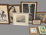 many framed and unframed art pieces on the table
