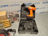 an orange corded drill in a case with other tools