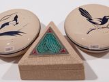 two small boxes with designs on them sitting on a table