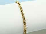 a gold chain bracelet on top of a white napkin
