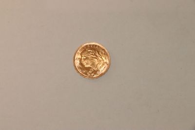 gros plan d'une pièce d'or sur une surface blanche