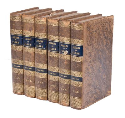 four old books sitting on top of each other on a white surface