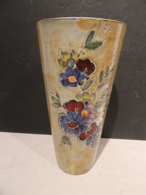 a vase with flowers painted on it sitting on a table