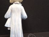 a figurine of a woman standing next to a cord